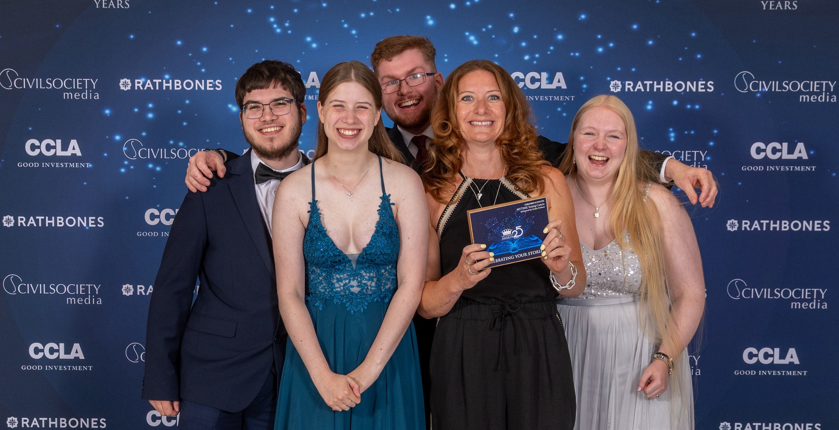 MYTIME Young Carers CEO Krista Cartlidge standing with four young carers and holding the 2025 Charity Awards trophy at the Royal Lancaster Hotel in London.